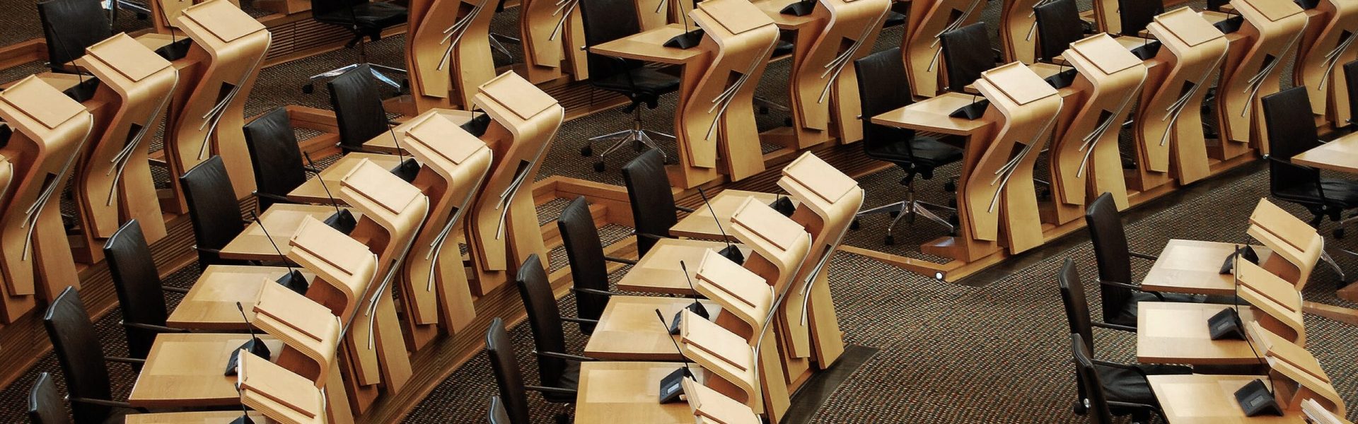 A horizontal shot of the desks inside of the Scottish parliament building